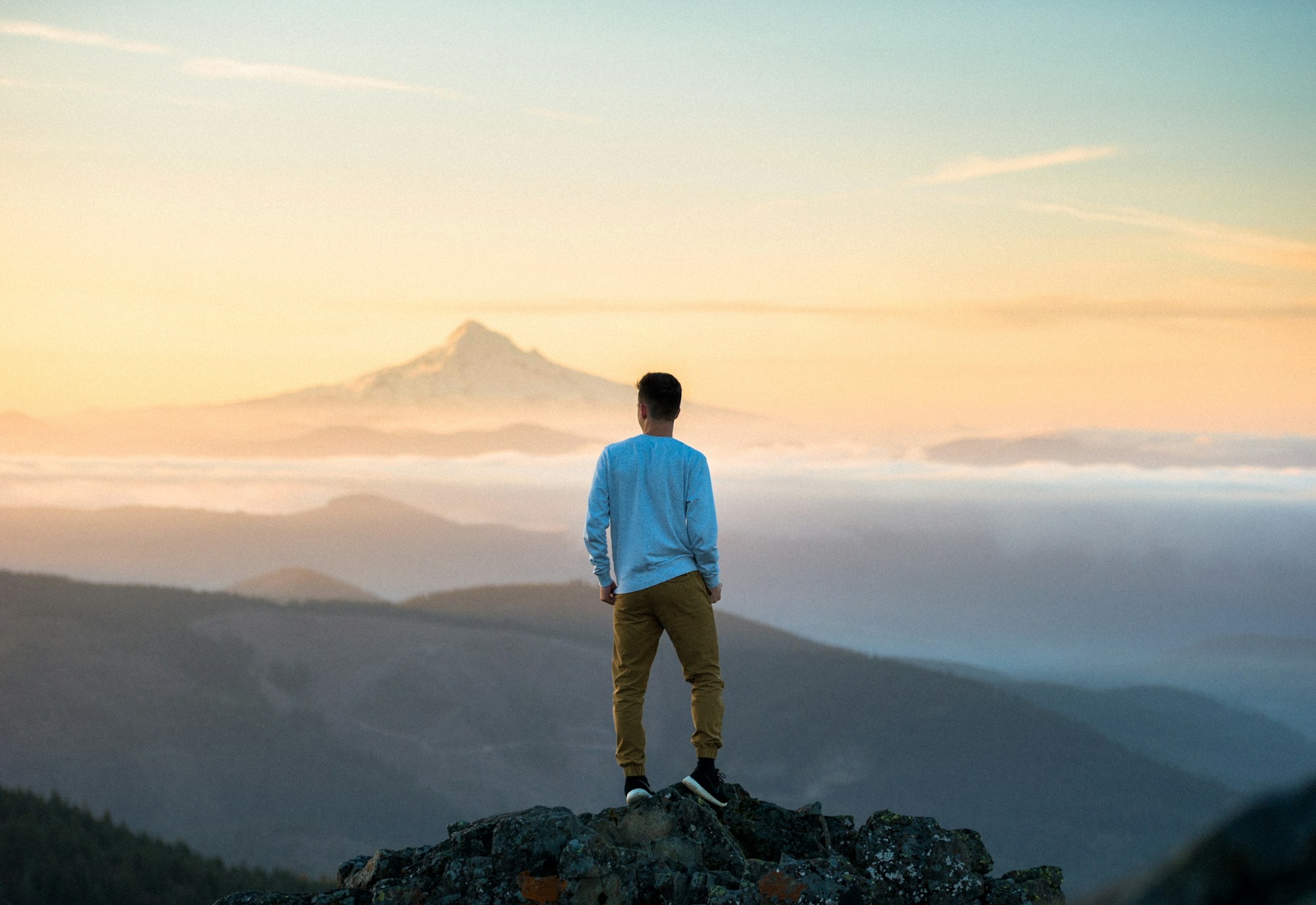 A person looking out over open hills at sunrise